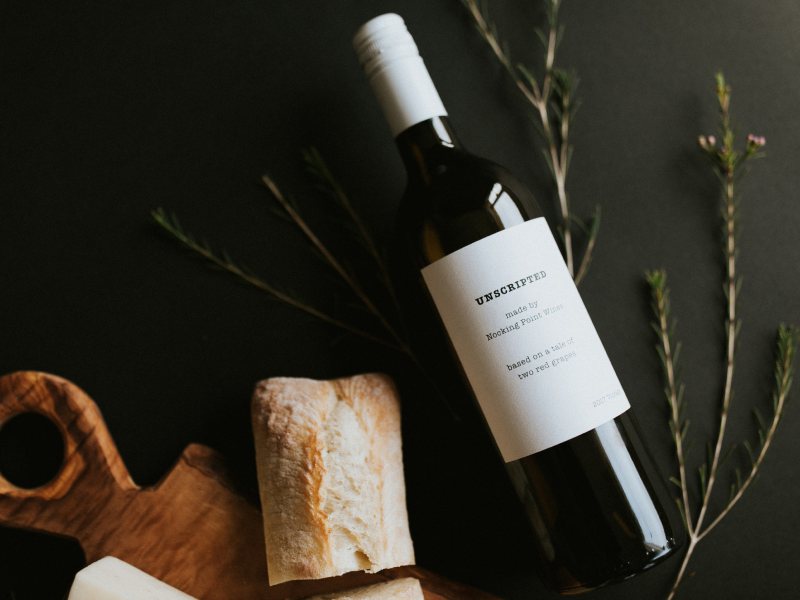Unscripted red wine bottle with bread and herbs